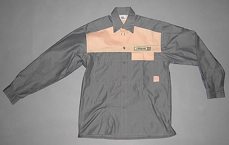 Hemd für Männer, sog. Hemd, Größe 39/40, siehe Abbildung, 
- aus verschiedenen, 0,3 mm dicken, buntgewebten Geweben aus lt. Antrag 
  50% Baumwolle und 50% Polyester (synthetische Chemiefasern),
- über die Taille reichend (Rückenlänge: 79 cm),
- mit einem halsnahen Umlegekragen,
- vorn mit einer durchgehenden Öffnung mit Knopfverschluss von links über rechts
  (Männerkleidung),
- mit langen Ärmeln, mit geknöpften Manschetten,
- mit aufgesetzten Brusttaschen, eine mit Patte mit Druckknopfverschluss,
- auf der Vorder- und Rückseite mit aufgenähten Firmennamen und Schriftzügen, 
- am unteren Rand durch Umschlagen und Festnähen gesäumt,
- keine Arbeits- oder Berufskleidung, u.a., da die Position 6205 dafür keine Unterposition 
  vorsieht.