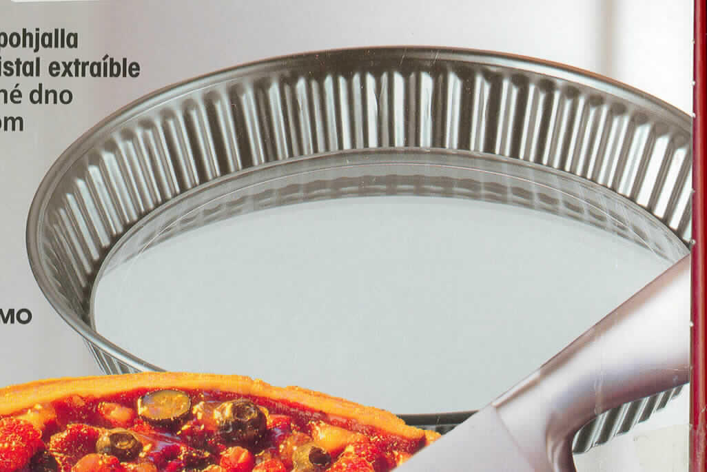 Glasware zur Verwendung in der Küche, sog. Obsttortenform mit Glasboden, Art. 3542,
siehe Foto, Kuchenbackform in Form einer zusammengesetzten Ware, bestehend aus
- einem Boden aus klarsichtigem Glas,
-- aus vorgespanntem Einschichten-Sicherheitsglas (lt. Antragsangaben),
-- kein Glas der Unterpositionen 7013 10, 7013 41 und 7013 42 der KN,
-- runde Platte mit einem Durchmesser von ca. 23 cm und einer Dicke von ca. 4 mm,
-- mit einem leicht abgerundeten Rand,
-- zur Verwendung als Boden der Backform und als Platte beim Schneiden des Kuchens,
- einem Backformring für Obsttorten aus beschichtetem Stahlblech,
-- am Rand wellenartig gearbeitet,
-- mit einem Durchmesser am oberen Rand von ca. 27,5 cm und einer Höhe von ca. 4 cm,
-- am unteren Ende ca. 1 cm nach innen gezogen zum Einsetzen des Bodens,
- der Boden aus Glas bestimmt nach dem Gewicht und insbesondere aufgrund seiner 
  multifunktionalen Bedeutung in Bezug auf die Verwendung (als Backboden sowie als
  Kuchenschneideplatte) den Charakter der zusammengesetzten Ware,
- verpackt in einer handelsüblichen Verkaufsumschließung (buntbedruckter Karton).