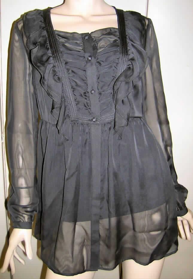 Hemdbluse für Frauen, sog. Bluse mit Untertop (Modell 56123), Größe 36, siehe Fotos,
- zweilagig gearbeitet:
-- Außenlage (nach Umfang, Wert und Gesamteindruck charakterbestimmend) aus 0,3 mm dicken, 
   einfarbigen, durchscheinenden Geweben aus lt. Antrag 100% Seide,
-- Innenlage aus 0,7 mm dicken, einfarbigen Gewirken aus lt. Antrag 100% Seide,
-- die Innenlage in Form eines modischen Unterhemdes ist in den Schulternähten der Außenlage fest 
   und dauerhaft vernäht; sie ist somit nicht als Kleidungsstück separat tragbar,
- über die Taille reichend (Rückenlänge: 73 cm),
- mit einem runden, halsnahen Ausschnitt ohne Kragen, 
- vorn mit einer durchgehender Öffnung mit Knopfverschluss von rechts über links (Frauenkleidung), 
- entlang der Öffnung bis unterhalb der Brust gerafft und mit angenähten Volants verziert,
- mit langen Ärmeln,
- am unteren, geraden Rand durch Umschlagen und Festnähen gesäumt,
- den Hemden für Männer entsprechend zugeschnitten.