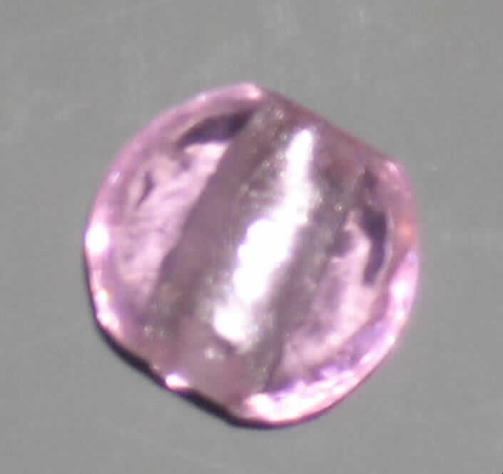 Glasperle, siehe Foto, 
- runde, linsenförmige, massive Perle aus vollständig durchbohrtem Glas, 
- - rosafarben mit Folieneinzug (lt. Antrag), 
- mit einem Durchmesser von ca. 20 mm und einer Dicke von ca. 10 mm, 
- nicht geschliffen und mechanisch poliert, da die Perle weder glatte und scharfkantig abge- 
  grenzte Schleifflächen (Facetten) noch einen geschliffenen Lochrand aufweist, 
- keine Nachahmung von echten Perlen, Zuchtperlen, Edel-, oder Schmucksteinen, 
- zum Herstellen von z.B. Halsketten u.ä. bestimmt, 
- augenscheinlich nicht handgearbeitet.