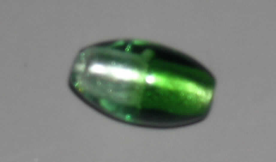 Glasperle, siehe Foto, 
- ovale, massive Perle aus vollständig durchbohrtem Glas, 
- - grünfarben mit Folieneinzug (lt. Antrag), 
- mit einer Länge von ca. 22 mm und einem Durchmesser von ca. 12 mm, 
- nicht geschliffen und mechanisch poliert, da die Perle weder glatte und scharfkantig abge- 
  grenzte Schleifflächen (Facetten) noch einen geschliffenen Lochrand aufweist, 
- keine Nachahmung von echten Perlen, Zuchtperlen, Edel-, oder Schmucksteinen, 
- zum Herstellen von z.B. Halsketten u.ä. bestimmt, 
- augenscheinlich nicht handgearbeitet.