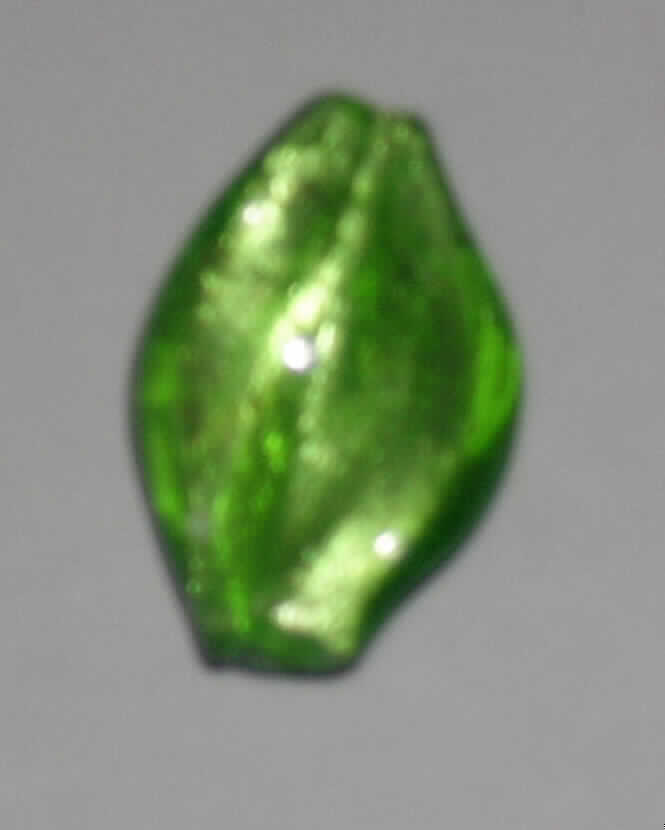 Glasperle, siehe Foto, 
- wellenförmige, massive Perle aus vollständig durchbohrtem Glas, 
- - grün mit Folieneinzug (lt. Antrag), 
- mit einer Länge von ca. 30 mm und einer Breite von ca. 20 mm, 
- nicht geschliffen und mechanisch poliert, da die Perle weder glatte und scharfkantig abge- 
  grenzte Schleifflächen (Facetten) noch einen geschliffenen Lochrand aufweist, 
- keine Nachahmung von echten Perlen, Zuchtperlen, Edel-, oder Schmucksteinen, 
- zum Herstellen von z.B. Halsketten u.ä. bestimmt, 
- augenscheinlich nicht handgearbeitet.
