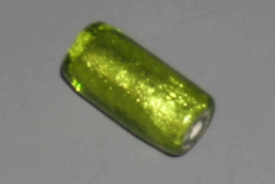 Glasperle, siehe Foto, 
- zylinderförmige, massive Perle aus vollständig durchbohrtem Glas, 
- - grün mit Folieneinzug (lt. Antrag), 
- mit einer Länge von ca. 22 mm und einem Durchmesser von ca. 10 mm, 
- nicht geschliffen und mechanisch poliert, da die Perle weder glatte und scharfkantig abge- 
  grenzte Schleifflächen (Facetten) noch einen geschliffenen Lochrand aufweist, 
- keine Nachahmung von echten Perlen, Zuchtperlen, Edel-, oder Schmucksteinen, 
- zum Herstellen von z.B. Halsketten u.ä. bestimmt, 
- augenscheinlich nicht handgearbeitet.
