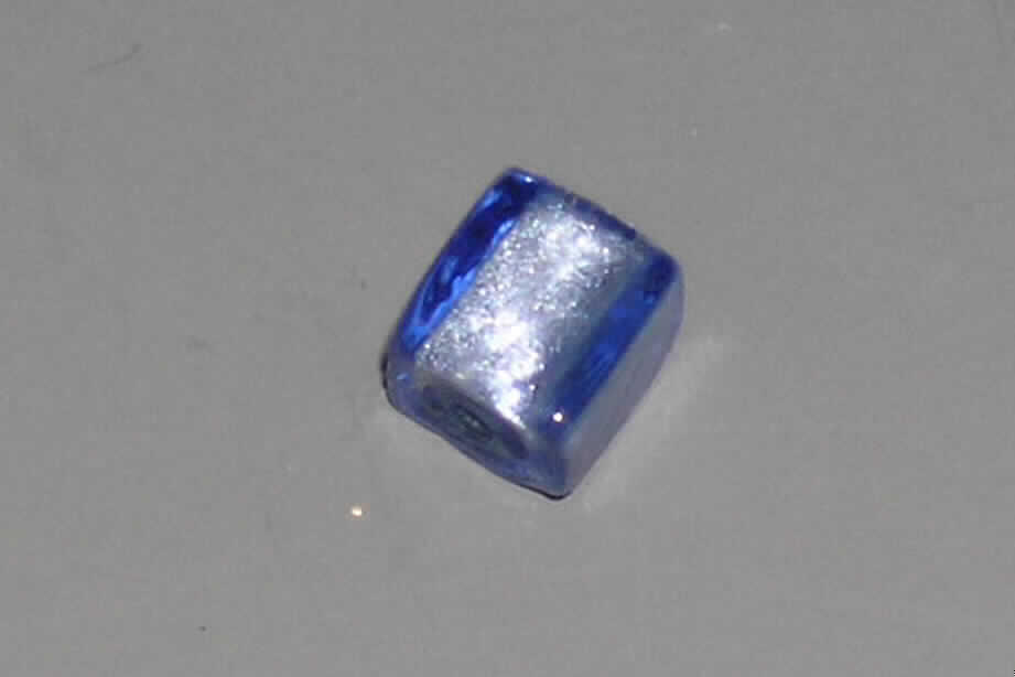 Glasperle, siehe Foto, 
- quaderförmige, massive Perle aus vollständig durchbohrtem Glas, 
- - blau mit Folieneinzug (lt. Antrag), 
- mit einer Seitenlänge von ca. 10 mm, 
- nicht geschliffen und mechanisch poliert, da die Perle weder glatte und scharfkantig abge- 
  grenzte Schleifflächen (Facetten) noch einen geschliffenen Lochrand aufweist, 
- keine Nachahmung von echten Perlen, Zuchtperlen, Edel-, oder Schmucksteinen, 
- zum Herstellen von z.B. Halsketten u.ä. bestimmt, 
- augenscheinlich nicht handgearbeitet.
