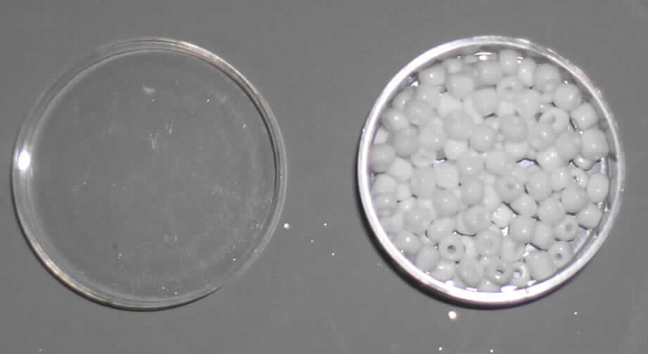Glasperlen (lt. Antrag Rocailles), siehe Foto, 
- runde, weiße, massive Perlen aus vollständig durchbohrtem Glas, 
- mit einem Durchmesser von ca. 4 mm und einer Höhe von ca. 3 mm, 
- nicht geschliffen und mechanisch poliert, da die Perlen weder glatte und scharfkantig abge- 
  grenzte Schleifflächen (Facetten) noch einen geschliffenen Lochrand aufweisen, 
- keine Nachahmung von echten Perlen, Zuchtperlen, Edel-, oder Schmucksteinen, 
- zum Herstellen von z.B. Halsketten u.ä. bestimmt, 
- augenscheinlich nicht handgearbeitet, 
- verpackt in einer Kunststoffdose (handelsübliche Verpackung).