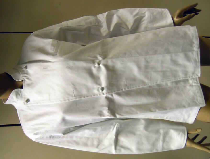 Jacke (Arbeitsjacke), sog. Kochjacke Exclusiv, Größe 42, siehe Foto,
- aus 0,6 mm dicken, einfarbigen (weiß), festen, köperbindigen Geweben aus laut Antrag
  100% Baumwolle,
- über den Schritt reichend (Rückenlänge: 74 cm); mit einem halsnahen Stehkragen, 
- vorne mit einer durchgehenden Öffnung mit zwei schräg verlaufenden, breiten Untertritten,
  die jeweils mit zwei Knopflochreihen ausgestattet sind,
- mit Steckknöpfen aus Kunststoff; das Kleidungsstück kann mit den Steckknöpfen sowohl
  von rechts auf links als auch von links auf rechts geknöpft werden, damit ohne Hinweise,
  die auf einen bestimmten Trägerkreis schließen lassen (unisex),
- mit langen, an den Enden gesäumten und geschlitzten Ärmeln,
- links mit einer Brusttasche und einer Tasche am linken Oberarm,
- am unteren Rand gesäumt,
- in Bahnen geschnitten, weist aufgrund des Bahnenschnitts und des festen Gewebes eine
  gewisse Formfestigkeit auf, u.a. deshalb keine Hemdbluse der Position 6206,
- insbesondere wegen des strapazierfähigen Materials, der Ausstattung (breite Untertritte) 
  und des einfachen, zweckbestimmten Schnitts erkennbar dazu bestimmt, ausschließlich 
  oder hauptsächlich zum Schutz der Person und/ oder der Kleidung bei der Ausübung einer 
  beruflichen Tätigkeit getragen zu werden.