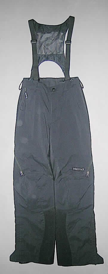 Latzhose für Männer, sog. Ski + Berghose  Art # 1115, Größe S, siehe beigefügtes Foto,
-  überwiegend (charakterbestimmend) aus einem 0,6 mm dicken, einfarbigen, 
   dreilagigen Flächenerzeugnis: 
-- mit einer charakterbestimmenden Außenlage aus einfarbigen Geweben, 
-- einer Zwischenlage aus Kunststofffolie, die im Querschnitt nicht mit bloßem Auge
   wahrnehmbar ist (Flächenerzeugnis keine Meterware der Position 5903),
-- und einer Innenlage aus gerauten Gewirken;
   im oberen Teil an den Außenseiten und im Rücken (teilweise doppelt gearbeitet), 
   sowie an den Innenseiten der Hosenbeine mit Einsätzen aus einem 1,8 mm dicken, 
   einfarbigen, dreilagigen Flächenerzeugnis:
-- mit einer Außenlage aus einfarbigen Gewirken, 
-- einer Zwischenlage aus Kunststofffolie, die im Querschnitt nicht mit blossem Auge
   wahrnehmbar ist (Flächenerzeugnis keine Meterware der Position 5903), 
-- und einer Innenlage aus gerauten Gewirken, 
-  im unteren Teil an den Außenseiten der Hosenbeine mit doppellagig gearbeiteten
   Einsätzen aus zwei, nur an den Nähten miteinander verbundenen, verschiedenen 
   einfarbigen Flächenerzeugnissen: 
-- einer (charakterbestimmend) oberen Lage aus mit Kunststoff (kein Zellkunststoff) 
   überzogenen Geweben (Meterware der Pos. 5903), 
-- und einer unteren Lage aus dem an erster Stelle beschriebenen, 0,6 mm dicken,   
   dreilagigen Flächenerzeugnis,
-  alle Flächenerzeugnisse aus lt. Textiletikett 100% synthetischen Chemiefasern,
-  mit einem abtrennbaren Rückenlatz aus netzartigen Gewirken und doppellagig gearbeiteten
   Zuschnitten mit einer Außenlage aus einfarbigen Geweben und einer Innenlage aus 
   gerauten Gewirken; mit elastischen, verstellbaren Trägern,
-  in der Taille abschließend, mit einem angesetzten Bund (im Rücken nicht durchgängig 
   als Bund gearbeitet), seitlich mit Gürtelschlaufen, vorn und hinten mit Klettverschluss- 
   laschen zum Befestigen des Rückenlatzes, 
-  vorn mit einer kurzen Öffnung mit Reißverschluss, verdeckt von einer von links 
   auf rechts überlappenden Patte (Männerkleidung), mit Klett- und Druckknopfverschluss 
   in der Taille,
-  an den Seiten mit Belüftungsschlitzen mit Reißverschluss, mit einem netzartigen 
   Gewirkeeinsatz unterlegt, 
-  vorn mit einer eingesetzten Tasche mit Reißverschluss,
-  im Kniebereich mit innen eingearbeiteten Protektorentaschen, mit herausnehmbaren 
   Protektoren,
-  nur vom Knie bis zu den Beinabschlüssen gefüttert,
-  mit knöchellangen Hosenbeinen, an den Abschlüssen mit ca. 23 cm hoch reichenden
   Seitenschlitzen mit Reißverschluss und einer kurzen Druckknopflasche; innen mit einem 
   eingenähten, seitlich zu öffnenden Schneefang mit Klett- und Druckknopfverschluss.
