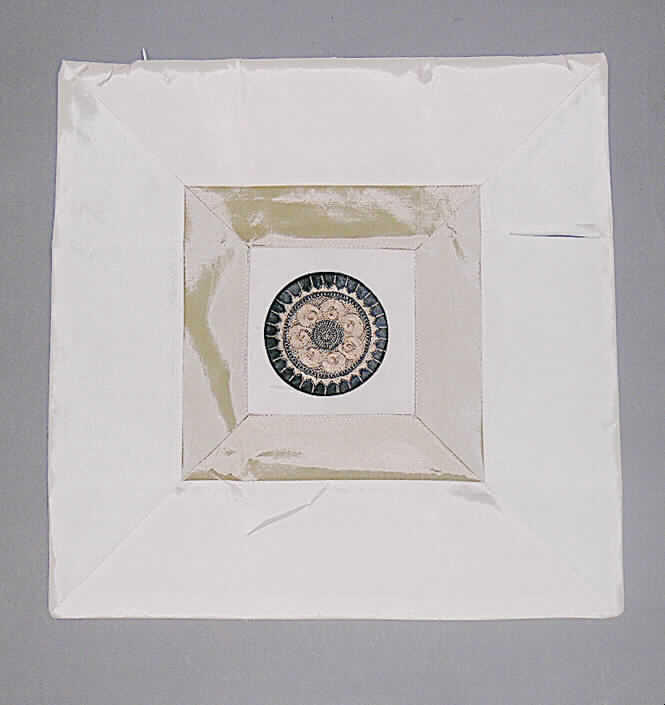 Ware zur Innenausstattung (Zierkissenhülle), sog. Zierkissenbezug (Art. A30-x0011-000), siehe Foto
- charakterbestimmend aus verschiedenen, 0,2 mm dicken, einfarbigen Geweben aus laut 
  Antrag 100 % Viskose (künstliche Chemiefasern), in der Mitte mit einem runden Zuschnitt 
  aus kontrastfarbenen Geweben mit aufgebrachter Applikationstickerei; die Gewebe sind mit
  einer 0,1 mm dicken, selbstklebenden Vlieseline aus synthetischen Chemiefasern 
  unterlegt,
- durch Zusammennähen konfektioniert; quadratisch, in den Abmessungen 43 cm x 43 cm,
- in einer Seitennaht mit einem Reißverschluss zum Einstecken der Kissenfüllung; kenn- 
  zeichnet sich nach Material, Ausstattung und Abmessung als Ware zur Innenausstattung 
  und wird üblicherweise nicht regelmäßig gewaschen; damit kein Kopfkissenbezug (Bett- 
  wäsche) der Pos. 6302.