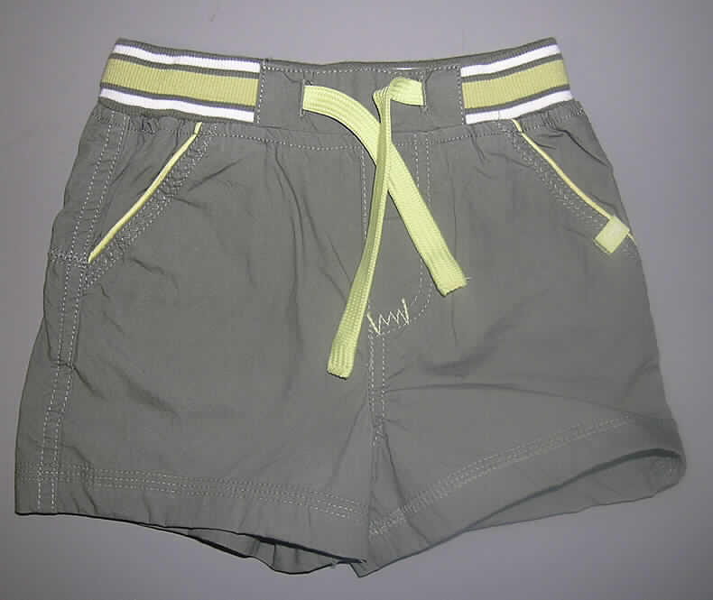 Kleidung für Kleinkinder, sog. Babyshorts, Größe 74, siehe Foto,
- aus 0,3 mm dicken, einfarbigen Geweben aus laut Etikett 100 % Baumwolle,
- als kurze Hose gearbeitet,
- in der Taille abschließend, mit einem buntgewirkten, gerippten Bund mit gewebtem 
  Kordelzug; ohne Öffnung und ohne Verschluss,
- vorn mit eingesetzten, offenen Eingriffstaschen mit kontrastfarbenen Paspelierungen,
- hinten mit zwei Patten mit kontrastfarbenen Paspelierungen, jedoch ohne Taschen,
- an den Beinabschlüssen gesäumt,
- kennzeichnet sich aufgrund der Konfektionsgröße als Kleidung für Kleinkinder.