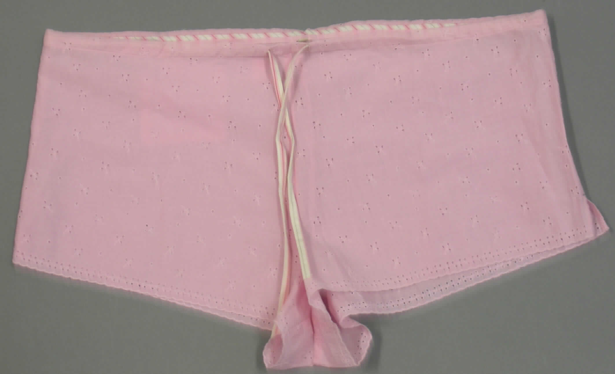 Kurze Hose, Größe 44, siehe Foto,
- aus 0,6 mm dicken, einfarbigen Lochstickereien der Position 5810 mit Stickgrund aus
  Geweben aus lt. Antrag 100% Baumwolle,
- in der Taille abschließend, mit einem Kordelzug am Taillenbund,
- ohne Öffnung und ohne Verschluss, somit ohne Merkmale, die auf einen bestimmten 
  Trägerkreis (Männer oder Frauen) hinweisen (unisex), 
- mit einer aufgesetzten Gesäßtasche,
- mit kurzen Hosenbeinen, die nicht die Knie bedecken (Seitenlänge: 24 cm),
- mit 4 cm hoch reichenden Seitenschlitzen,
- an den Beinabschlüssen bogig geschnitten und gesäumt,
- ohne Schrittfutter oder Hygieneeinlage, somit keine Unterhose der Position 6208.