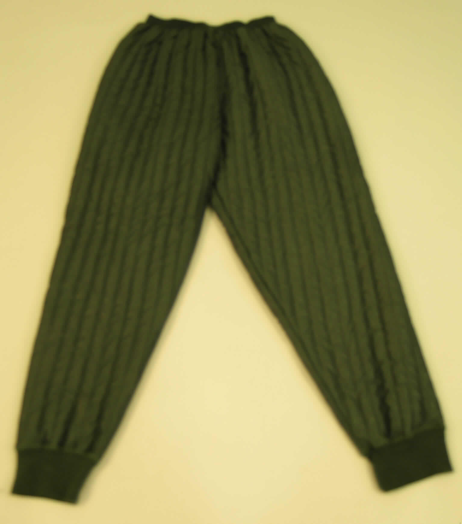 Zusammenstellung aus pulloverähnlichem Kleidungsstück und langer Hose, sog. Thermo Unterwäsche, Artikelnr. 96923, Größe XL, in Aufmachung für den Einzelverkauf, siehe Fotos;
- aus einem 2,5 mm dicken, dreilagigen, durch Steppen abgeteilten Verbunderzeugnis der 
  Pos. 5811 mit Außenseite aus Gewirken aus lt. ergänzenden Antragsangaben 50% Baum- 
  wolle, 30% Polyamid und 20% Polyester (beides synth. Chemiefasern), Zwischenlage aus 
  Wattierungsstoff und Innenlage aus Gewirken,
- keine Kombination, weil die Kleidungsstücke nicht aus ein und demselben Flächenerzeug- 
  nis hergestellt sind, die Verschiedenheit ergibt sich u.a. aus den anders strukturierten, 
  angesetzten Bündchen an den Kleidungsstücken,
- kennzeichnet sich aufgrund der Ausstattung und des Verwendungszweckes (wird als Ang- 
  lerkleidung zwischen Unterwäsche und Oberkleidung getragen) nicht als 
  Unterwäsche und stellt auch keinen Trainingsanzug dar,
 - lange Hose: 
-- in der Taille abschließend; mit einem angesetzten, durchgehenden, elastischen, anders 
   strukturierten Taillenbund; vorn unterhalb des Taillenbundes mit einer ca. 20 cm langen 
   mit Reißverschluss zu schließenden Eingriffsöffnung (erkennbar Männerkleidung),
-- mit langen, bis zu den Knöcheln reichenden Hosenbeinen,
-- mit verengenden, anders strukturierten Bündchen an den Beinabschlüssen.