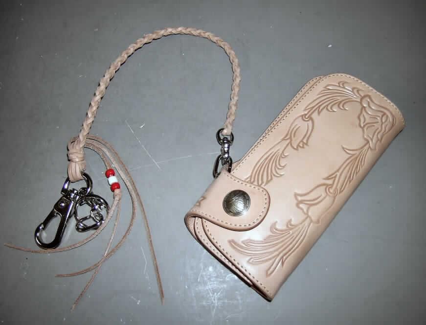 Geldbörse, Taschen- oder Handtaschenartikel, sog. "Lederportemonaie", siehe Foto,
- mit einer Außenseite aus hellbraunem Leder,
- mit eingestanztem Blumenmuster,
- mit den Abmessungen ca. 19 x 9 x 3 cm,
- zweiseitig aufklappbar,
- mit einem Druckknopfverschluss,
- mit einem Münzfach mit Reißverschluss und zwei Scheinfächern,
- mit einem ca. 11 cm langen, geflochtenen Lederriemen mit einem Schlüsselanhänger 
  und einem Karabinerhaken aus unedlen Metallen,
- laut Antragsangaben handgearbeitet (Handarbeit nicht belegt),
- verpackt in einem handelsüblichen Karton.