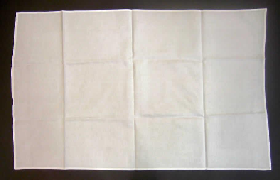 Tischwäsche (Tischdecke), siehe Foto,
- rechteckig, laut Antrag in den Abmessungen von 64 cm x 107 cm,
- aus 0,7 mm dicken, einfarbigen Geweben aus laut Antrag 100% Baumwolle,
- an allen Rändern gesäumt (somit konfektioniert),  
- wird üblicherweise regelmäßig gewaschen und kennzeichnet sich nach Material, 
  Ausstattung und Verwendungszweck als Tischwäsche, somit keine Ware zur 
  Innenausstattung (Zierdecke) im Sinne der Position 6304.