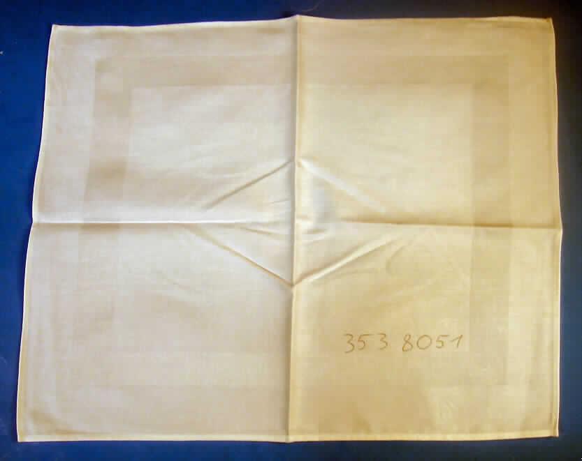 Tischwäsche (Tischdecke), siehe Foto,
- rechteckig, laut Antrag in den Abmessungen von 50 cm x 60 cm,
- aus 0,7 mm dicken, einfarbigen Geweben aus laut Antrag 100% Baumwolle,
- an allen Rändern gesäumt (somit konfektioniert),  
- wird üblicherweise regelmäßig gewaschen und kennzeichnet sich nach Material, 
  Ausstattung und Verwendungszweck als Tischwäsche, somit keine Ware zur 
  Innenausstattung (Zierdecke) im Sinne der Position 6304.
