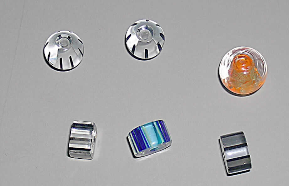 Glasperlen (lt. Antrag Glasperlen, Art.-Nrn. 21152, 21156 bis 21158 und 21167 bis 21169), 
siehe Foto, 
- massive Perlen aus vollständig durchbohrtem Glas,
- in verschiedenen Formen und Größen (rund, zylinderisch, kubusförmig), 
- in verschiedenen Farben (01 - 47 bzw. 16 - 89), 
- nicht geschliffen und mechanisch poliert, da die Perlen weder glatte und scharfkantig abge- 
  grenzte Schleifflächen (Facetten) noch einen geschliffenen Lochrand aufweisen, 
- keine Nachahmung von echten Perlen, Zuchtperlen, Edel-, oder Schmucksteinen, 
- zum Herstellen von z.B. Halsketten u.ä. bestimmt, 
- augenscheinlich nicht handgearbeitet.