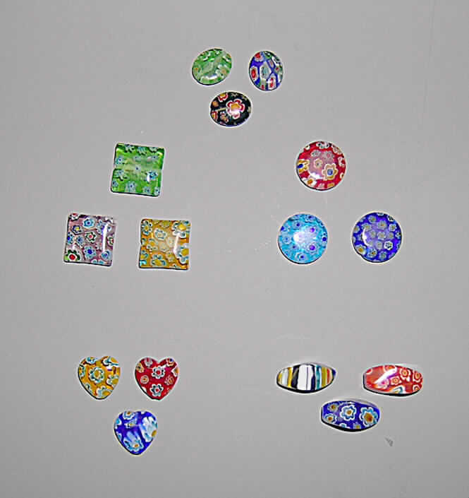 Glasperlen (lt. Antrag Glasperlen "Mille fiori", Art.-Nrn. 21220 bis 21224 und 21225 bis 
21229), siehe Foto, 
- bunte, überwiegend flache, massive Perlen aus vollständig durchbohrtem Glas,
- in verschiedenen Formen, 
- - rund, mit einem Durchmesser von 14 mm und einer Höhe von 4 mm, 
- - quadratisch, mit den Abmessungen von ca. 14 (L) x 14 (B) x 4 (H) mm, 
- - oval, mit den Abmessungen von ca. 12 (L) x 10 (B) x 4 (H) mm, 
- - herzförmig, mit den Abmessungen von ca. 12 (L) x 12 (B) x 4 (H) mm, 
- - olivenförmig, mit den Abmessungen von ca. 16 (L) x 8 (B) x 8 (H) mm, 
- in verschiedenen Farben (00 - 89), 
- nicht geschliffen und mechanisch poliert, da die Perlen weder glatte und scharfkantig abge- 
  grenzte Schleifflächen (Facetten) noch einen geschliffenen Lochrand aufweisen, 
- keine Nachahmung von echten Perlen, Zuchtperlen, Edel-, oder Schmucksteinen, 
- zum Herstellen von z.B. Halsketten u.ä. bestimmt, 
- augenscheinlich nicht handgearbeitet.