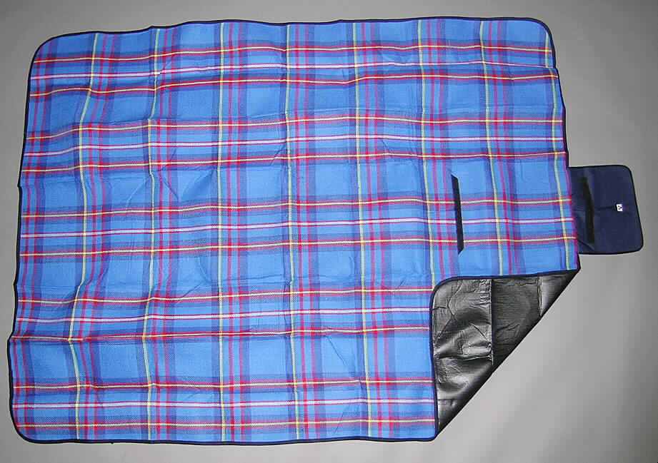 Decke, sog. Picknickdecke (Art. 800 278 "Karo"), siehe Fotos,
- rechteckig, in den Abmessungen von etwa 170 x 135 cm; mit abgerundeten Ecken,
- aus einem dreilagigen Verbunderzeugnis der Position 5903, bestehend aus einem buntge- 
  webten Gewebe aus laut ergänzenden Antragsangaben 100% Polyester (synthetische 
  Chemiefasern); auf der einen Seite mit zwei Lagen aus Kunststoff ( ca. 1 mm dicker Zell- 
  kunststoff (Schaumkunststoff)) und Kunststofffolie (PVC/ kein Zellkunststoff)) überzogen,
- an allen Seiten mit einem 1 cm breiten, gewebten Band eingefasst (somit  konfektioniert),
- nicht handgearbeitet; ohne elektrische Heizvorrichtung, 
- an einer Längsseite mit einer angenähten Umschlaglasche mit Tragegriff, die es ermöglicht, 
  die zusammengelegte Decke in Art einer Tasche (20 x 35 cm) zu tragen,
- insbesondere nach den Abmessungen und dem Material handelt es sich um eine Decke, 
  die auf Ausflügen oder Reisen verwendet wird (somit keine Ware zur Innenausstattung der 
  Position 6304), aufgrund der geringen Polsterung keine Ware der Position 9404.
