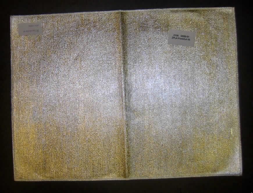 Ware zur Innenausstattung, sog. Tischset Lurex, siehe Foto,
- laut Untersuchungsergebnis aus einem rohen Gewebe in Ripsbindung aus 51,1 % Jute 
  und 48.9% Baumwolle, einseitig (Schauseite) mit einer metallisierten Kunststofffolie (kein 
  Zellkunststoff) überzogen,
- rechteckig zugeschnitten (Abmessungen: 45 cm x 33 cm),
- an allen Seiten durch Überwendlichnähte gesäumt (damit konfektioniert),
- wird (aufgrund des Kunststoffüberzugs) üblicherweise nicht regelmäßig gewaschen (somit 
  keine Tischwäsche der Position 6302).