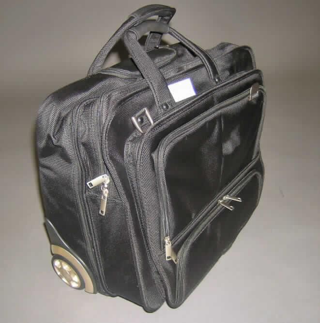Aktenkofferähnliches Behältnis mit Trolleyfunktion, siehe Foto, 
- mit einer Außenseite aus Spinnstoffen, 
- mit einem ausziehbaren Griff zum Ziehen des Koffers auf zwei Rollen und einem Standfuß 
  aus Kunststoff, 
- mit einem abnehmbaren, gepolsterten Schultertragegurt und zwei Handtragegriffen,
- mit den Abmessungen von ca. 47 (L) x 39 (H) x 26 (T) cm, 
- mit zwei Hauptfächern, jeweils mit Doppelreißverschluss zu öffnen, mit Einschubfächern 
  und einem gepolsterten Laptopfach, 
- mit drei aufgesetzten Vorfächern, jeweils mit Doppelreißverschluss zu öffnen, ausgestattet 
  mit u.a. Handyfach, Stiftlaschen, Adressfach und diversen anderen Einsteckmöglichkeiten 
  mit Reiß- oder Klettverschlüssen, 
- kein nicht selbstfahrendes Fahrzeug der Pos. 8716, 
- augenscheinlich nicht handgearbeitet.