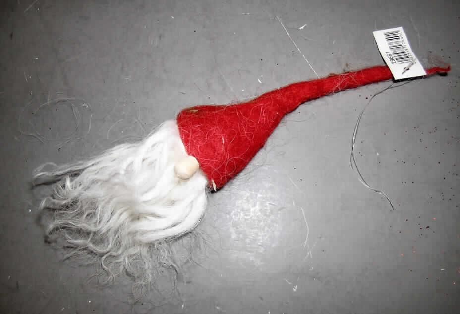 Andere konfektionierte Spinnstoffware, sog. Hänger Santa, siehe Foto,
- ca. 25 cm große Figur in Form eines stilisierten Wichtelkopfes (laut Antrag Santakopf),
- durch Zusammenkleben konfektioniert; nicht handgearbeitet,
- besteht aus einer etwa 16 cm langen Zipfelmütze aus Filz aus Spinnstoffen, an deren
  unteren Rand üppige, etwa 9 cm lange, gewellte, fransenartige Spinnstofffasern aus laut
  Antrag Wolle angebracht sind, die stilisierte Haare und einen Bart darstellen sollen, sowie
  einer kleinen Holzkugel als Nase,
- soll als Dekorationsartikel benutzt werden,
- die Ware hat trotz roter Zipfelmütze aufgrund ihrer Beschaffenheit keinen weihnachtlichen
  Bezug, insbesondere handelt es sich nicht um einen Weihnachtsmannkopf, damit keine
  Ware der Position 9505,
- insbesondere aufgrund der geringen Größe ohne raumbezogene Funktion, damit keine 
  Ware zur Innenausstattung der Position 6304,
- weder der Filz noch die Garne verleihen der Ware ihren wesentlichen Charakter; sie ist 
  damit der von den gleichermaßen in Betracht kommenden Unterpositionen (6307 9091 
  und 6307 9099) in der Nomenklatur zuletzt genannten zuzuweisen.