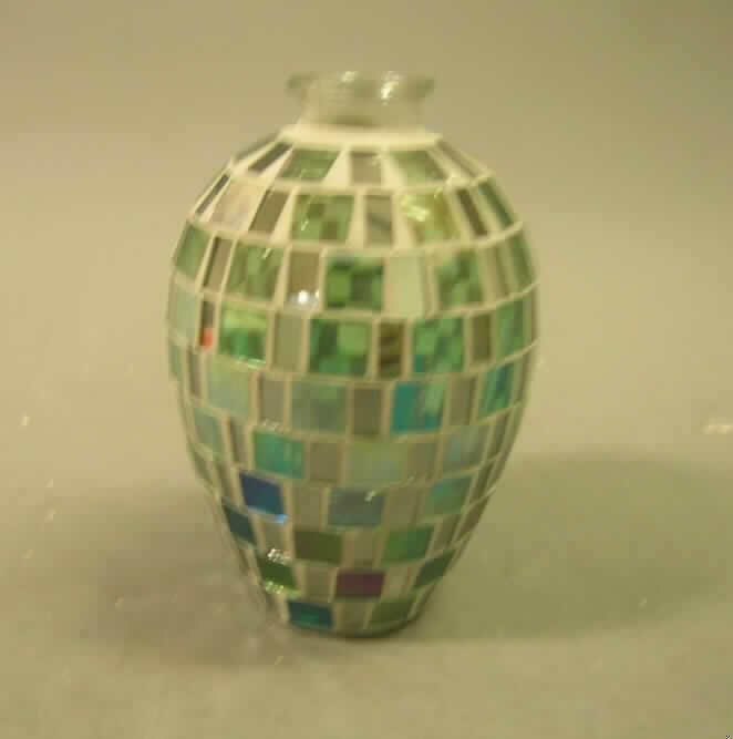 Flasche für Verpackungszwecke, sog. Mosaik-Glas-Flasche, Art.-Nr.: 1021674, siehe Foto,
- Flasche in Form einer Amphore, mit angesetztem Flaschenhals für einen Stopfen,
- aus augenscheinlich gewöhnlichem, nicht gefärbtem Glas,
- an der Außenseite mit Glasmosaik verziert,
- mit einer Höhe von ca. 14 cm,
- mit einem Fassungsvermögen von weniger als 2,5 Liter,
- ohne Stopfen,
- lt. Antrag als Verkaufsaufmachung für Badeschaum bestimmt.
