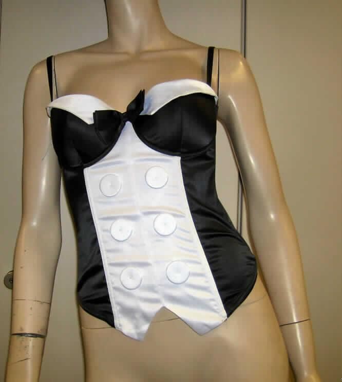 Bluse für Frauen, sog. Penguin Corset, Artikel 650890, Größe 75 B, siehe Fotos,
- aus verschiedenen 0,3 mm dicken, leichten, einfarbigen Geweben aus laut Antrag 95 % Polyester und 
  5 % Elastan (beides Chemiefasern); im Vorderteil teilweise mit einem 0,3 mm dicken Futter unterlegt 
  (kennzeichnet sich aufgrund der Gesamtdicke noch als leichtes Kleidungsstück), 
- über die Taille reichend (Rückenlänge: 43 cm); vorn spitz zulaufend ca. 10 cm länger gearbeitet,
- mit schmalen, verstellbaren, abnehmbaren Schulterträgern, 
- hinten mit einer durchgehenden Öffnung mit Hakenverschluss,
- mit ausgearbeiteten, gepolsterten Büstenteilen mit Formbügeln, somit erkennbar Frauenkleidung; 
  mit einer ca. 10 cm x 5 cm großen Schleife sowie kontrastfarbenen Zuschnitten am oberen Rand verziert,
- mit eingearbeiteten Stäbchen aus Kunststoff; tailliert gearbeitet,
- vorn mit aufgenähten, mit Stoff überzogenen Zierknöpfen; am unteren Rand gesäumt,
- im Rücken mit Einsätzen aus durchbrochenen Gewirken,
- wird sichtbar als Oberkleidung getragen, somit u.a. kein Korsett/keine Miederware der Position 6212,
- erfüllt die Begriffsbestimmungen zur Einreihung als Bluse in die Position 6206, somit keine andere 
  Kleidung der Position 6211.