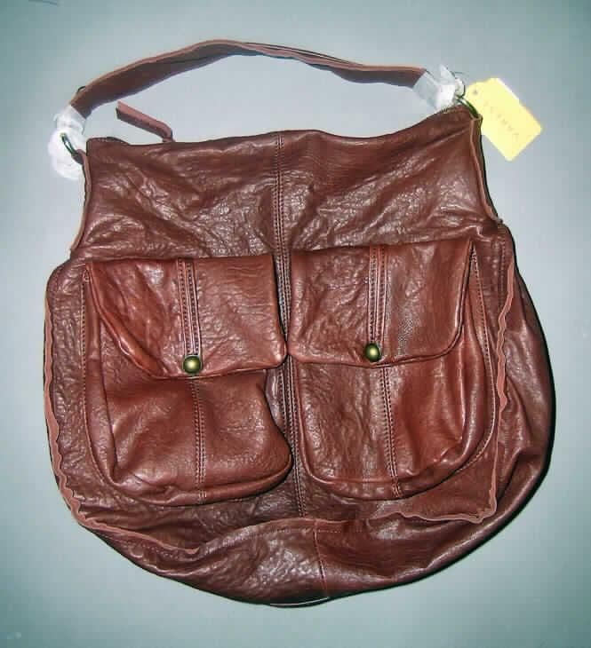 Umhängetasche, sog. Handtasche, siehe Foto,
- mit einer Außenseite aus Leder (zugerichtet),
- mit einem Tragegurt,
- mit zwei aufgesetzten Vortaschen mit Überschlagklappe mit Magnetknopfverschluss,
- Hauptfach mit einem entlang dem oberen Rand verlaufenden Reißverschluss zu öffnen,
- gefüttert, mit einem eingesetzten Reißverschlussfach und zwei aufgenähten Einsteckfächer 
  ausgestattet, 
- mit einer Größe von ca. 40 x 16 x 38 cm,
- keine Handtasche aufgrund der Machart und der Größe, 
- augenscheinlich nicht handgearbeitet.
