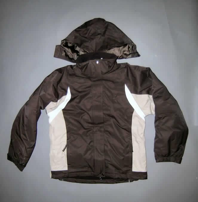 Anorak aus Geweben der Position 5903, sog. Reit- und Freizeitjacke Kentucky (Art. 15131), Größe XXL, siehe Foto,
- aus verschiedenen, 0,3 mm dicken, einfarbigen, einseitig (Innenseite) mit Kunststoff (lt. Untersuchungsergebnis 
  kein Zellkunststoff) überzogenen Geweben der Position 5903 (somit keine Ware der Position 6202),
- gefüttert,
- über den Schritt reichend (Rückenlänge: 76 cm); vorn ca. 5 cm kürzer gearbeitet,
- mit einem Stehkragen mit integrierter, abtrennbarer Kapuze,
- vorn mit einer durchgehenden Öffnung mit Reißverschluss und Patte mit Klettverschluss von rechts über
  links (Frauenkleidung),
- mit langen Ärmeln; mit Klettriegeln an den teilweise elastischen Abschlüssen,
- vorn mit zwei eingesetzten Taschen unterhalb der Taille, mit Reißverschluss,
- am unteren Rand gesäumt und hinten mit zwei ca. 15 cm hoch reichenden, erweiternden Einsätzen ausgestattet.