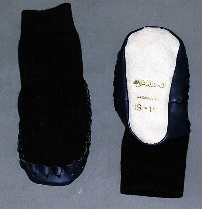 Hausschuhe für Kinder  (lt. Antrag: "Hüttenschuh, Artikel Nr.: 591 - 156", siehe Photographie)
- mit angebrachten Laufsohlen aus Leder,
- mit Oberteil aus Spinnstoffen (Schlingengewirke),
- auf das Oberteil sind am unteren Rand Stücke aus Kunststoff (Spinnstofferzeugnisse
  mit einer mit bloßem Auge wahrnehmbaren Außenschicht aus Kunststoff) als 
  Verstärkungsteile aufgesetzt