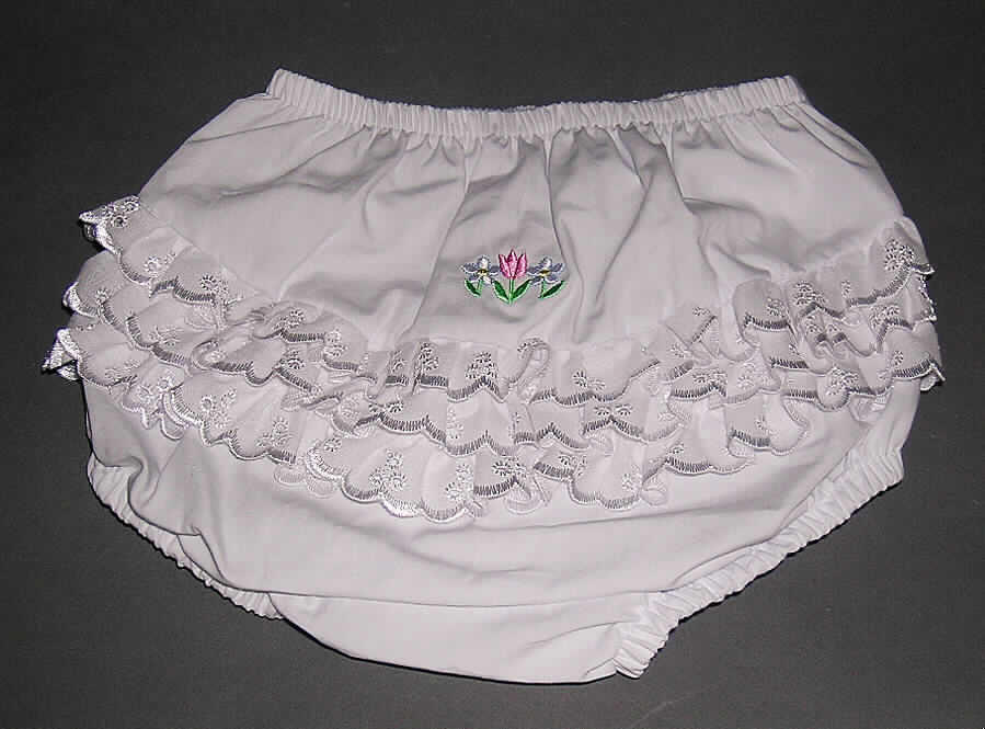 Kurze Hose, sog. Rüschenunterhose (Art. IP 682 Fancy Pants ), für Kinder ab 2 Jahren (entspricht Größe 92 und größer, somit keine Kleidung für Kleinkinder), siehe Foto,
- aus 0,2 mm dicken, einfarbigen Geweben aus lt. Antrag 100% Baumwolle,
- in der Taille abschließend mit elastischem Bund,
- ohne Öffnung und ohne Verschluss, somit ohne Merkmale, die auf einem bestimmten
  Trägerkreis (Knaben oder Mädchen) hinweisen (unisex),
- im Gesäßteil mit eingenähten Streifen aus bogenförmigen Stickereien der Position 5810 
  sowie einer Stickerei (Blumen) verziert,
- ohne Schrittfutter oder Hygieneeinlage, somit keine Unterhose der Position 6208,
- mit enganliegenden, elastischen Abschlüssen an den Beinausschnitten.