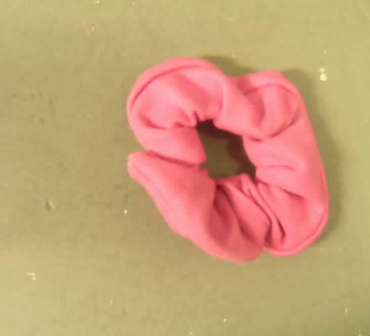 Dreiteilige Zusammenstellung (modisches Unterhemd, lange Hose und Bekleidungszubehör), sog. Mädchen-Schlafanzug mit Haarband (Art. 0883813001002), Größe 116, siehe Fotos,
- aus verschiedenen, 0,8 mm dicken, leichten, einfarbigen (pink und hellrosa) Gewirken aus   lt. Antrag 100% Baumwolle,
- nach Schnitt, farblicher Gestaltung und Ausstattung nicht erkennbar dazu bestimmt, ausschließlich oder 
  im Wesentlichen als Nachtkleidung im Bett getragen zu werden, somit kein Schlafanzug,
- keine Kombination, u. a. weil ein modisches Unterhemd als Bestandteil nicht zugelassen ist,
- getrennte Einreihung aller Bestandteile der Zusammenstellung, u. a. weil das modische Unterhemd und
  die lange Hose nicht zusammen in eine Position eingereiht werden dürfen,
- Bekleidungszubehör (Haarband/Zopfhalter):
-- durch schlauch- und ringförmiges Zusammennähen hergestellt, damit konfektioniert,
-- weder gummielastisch noch kautschutiert, 
-- ein elastisches Band enthaltend und dadurch gerafft,
-- in flachliegendem Zustand mit einem Außendurchmesser von ca. 9 cm,
-- wird zum Zusammenhalten des Haares und zugleich als Kopf-/Haarschmuck getragen,
-- in Anbetracht des textilen Charakters wird die Ware nicht vom Warenkreis der Position 9615
   erfasst.