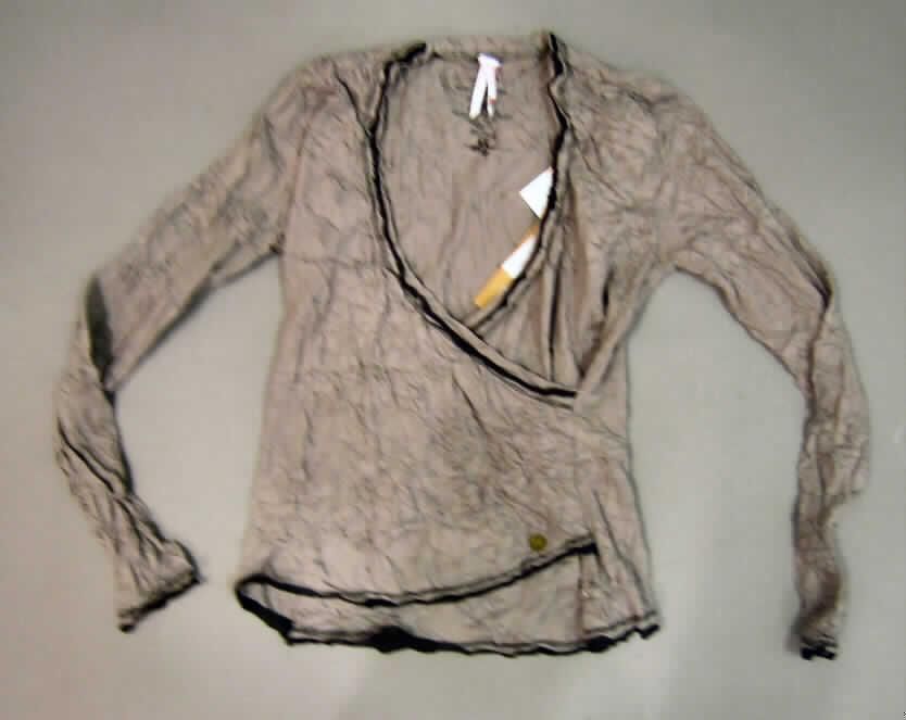 Bluse für Frauen, sog. hemdblusenähnliches Kleidungsstück, Größe S, siehe  beigefügtes Foto,
- aus 0,5 mm dicken, einfarbigen und bedruckten, gecrashten Gewirken aus lt. Antrag 100%
  Baumwolle; mit durchschnittlich mehr als 10 Maschen je linearen Zentimeter in jeder Richtung,
- über die Taille reichend (Rückenlänge 59 cm),
- mit einem sehr tiefen, V-förmigen Halsausschnitt (der Halsausschnitt unterschreitet die
  imaginäre Linie zwischen den Achselhöhlen), somit keine Ware der Position 6109,  
- ohne Öffnung und ohne Verschluss, mit asymmetrisch gearbeiteten Vorderteilen mit 
  Überlappung von rechts auf links (Frauenkleidung),
- mit langen Ärmeln, 
- an allen Rändern mit schmalen, angenähten, kontrastfarben Streifen aus Gewirken aus lt.
  Antrag 100% Baumwolle.