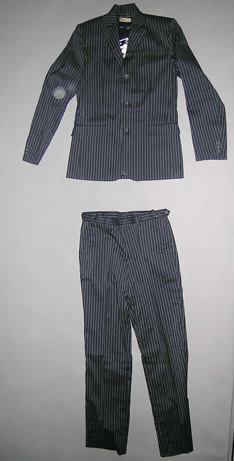Anzug für Knaben (Jacke und lange Hose), sog. Anzug für Jungs  Art. 592-665, Gr. 176, siehe Foto,
- in gemeinsamer Aufmachung für den Einzelverkauf,
- aus 0,3 mm dicken, buntgewebten Geweben (Nadelstreifenmuster) aus lt. Antrag 
  67% Baumwolle, 29% Polyamid und 4% Elastan (beides synthetische Chemiefasern), 
 - vollständig aus ein und demselben Flächenerzeugnis hergestellt und gleich in Struktur, 
   Stil, stofflicher Zusammensetzung, Farbe und Größe; 
- Jacke: 
-- über den Schritt reichend (Rückenlänge: 75 cm),
-- mit einer Außenseite - ohne Ärmel - aus 6 Längsteilen (Bahnen); mit einem Reverskragen,
-- vorn mit einer durchgehenden Öffnung mit Knopfverschluss von links über rechts (Knaben- 
   kleidung), gefüttert; mit langen Ärmeln, mit Zierknöpfen; mit Taschen,
-- im Rückenteil mit einem  22 cm hoch reichenden Mittelschlitz; am unteren Rand gesäumt,
- Lange Hose:
-- in der Taille abschließend, mit einem angesetzten Bund, mit Gürtelschlaufen, 
-- vorn mit einer Öffnung mit Reißverschluss, in der Taille mit einem Hakenverschluss von
   links über rechts (Knabenkleidung); nicht gefüttert,
-- mit einer Gesäßtasche mit Knopfverschluss und zwei eingesetzten Taschen vorn,
-- mit knöchellangen Hosenbeinen, am unteren Rand gesäumt.