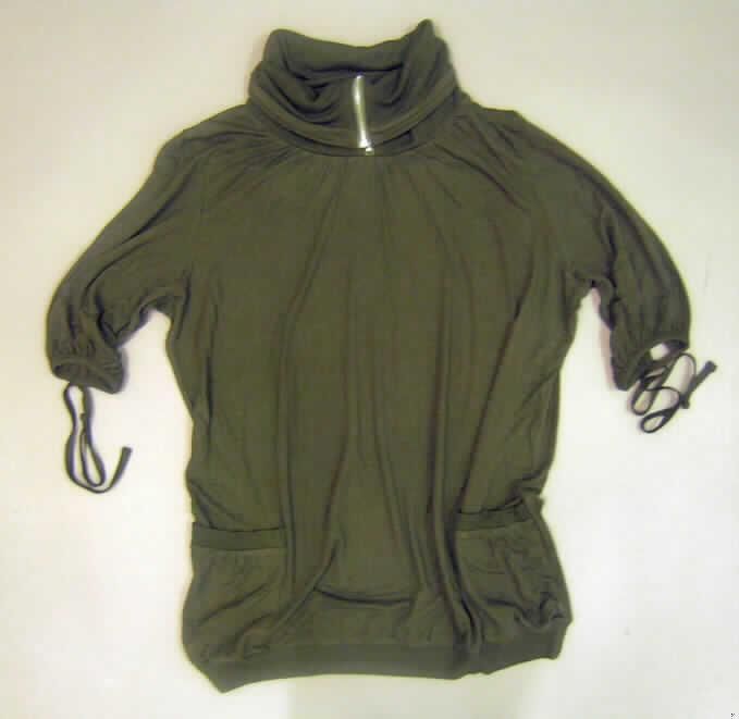 Pullover, sog. Blusenshirt, Art. Nr. 645195, in Erwachsenengröße, siehe Foto,
- überwiegend aus 0,7 mm dicken, glatten, einfarbigen Gewirken aus laut Antrag 100 % Viskose (Chemiefasern), 
- über den Schritt reichend (Rückenlänge: 76 cm),
- mit einem hohen, gerippten Rollkragen (u.a. deshalb keine Ware der Position 6109), mit Reißverschluss, 
  der nur den Kragen öffnet,
- ohne Merkmale, die auf einen bestimmten Trägerkreis (Männer oder Frauen) hinweisen (unisex),
- mit halblangen Ärmeln, mit gewirkten Randeinfassungen, die zu 35 cm langen Bindebändern verlängert sind, 
- mit aufgesetzten Taschen unterhalb der Taille, u.a. deshalb keine Bluse der Position 6106,
- am unteren Rand mit geripptem, verengendem Abschluss.