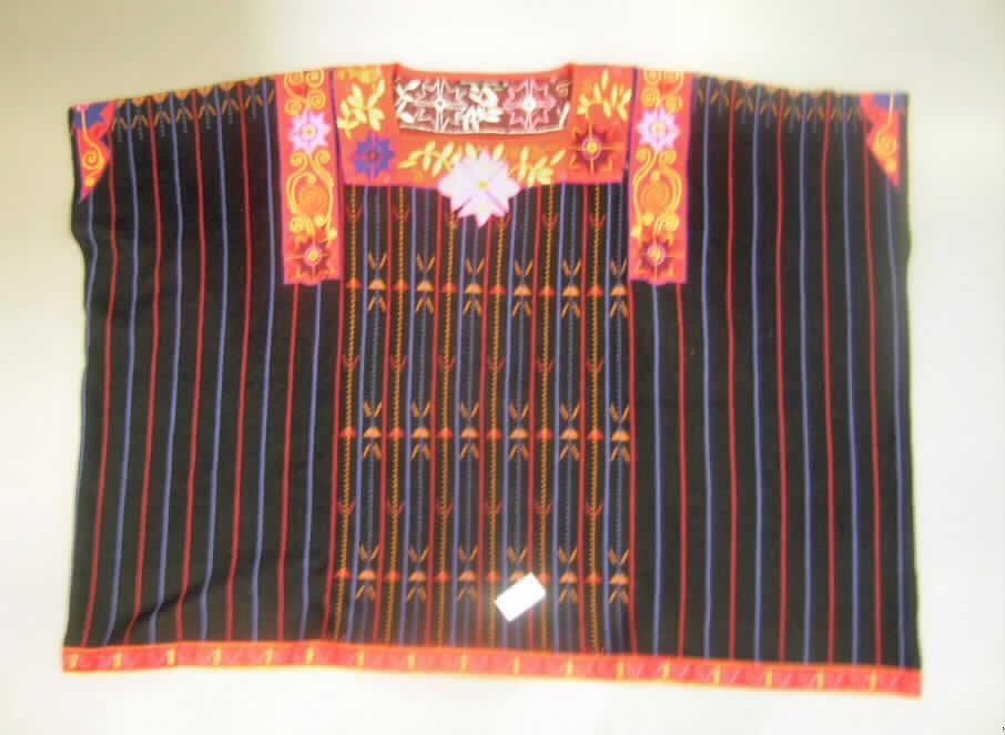 Pullover, sog. Jacquardstrick-Poncho "Ixil" (Art. Nr. 30 86-500), Größe M, siehe Foto,
- aus 1,8 mm dicken, buntgewirkten Gewirken aus laut Antrag 55% Seide und 45% Wolle,
- flachliegend von rechteckiger Form mit den Abmessungen 106 cm x 76 cm,
- in getragenem Zustand über den Schritt, aber nicht über den halben Oberschenkel reichend
  (Rückenlänge: 79 cm); kann aufgrund der geringen Länge nicht ohne ein weiteres, den
  Unterkörper bedeckendes Kleidungsstück (Rock oder Hose) getragen werden, somit kein
  Kleid der Position 6104,
- weit geschnitten, in der Art eines Ponchos,
- mit einem U-Bootförmigen, leicht halsfernen Ausschnitt,
- ohne Öffnung und ohne Verschluss; ohne Merkmale auf einen bestimmten Trägerkreis
  (unisex),
- mit Armöffnungen gearbeitet, jedoch ohne Ärmel; bedeckt in getragenem Zustand die
  Schultern und lediglich die Oberarme, damit keine Ware der Position 6102,
- an dem Halsauschnitt, dem unteren Rand, den Armabschlüssen und im Schulterbereich mit
  Stickereiborten versehen,
- am unteren Rand gesäumt.