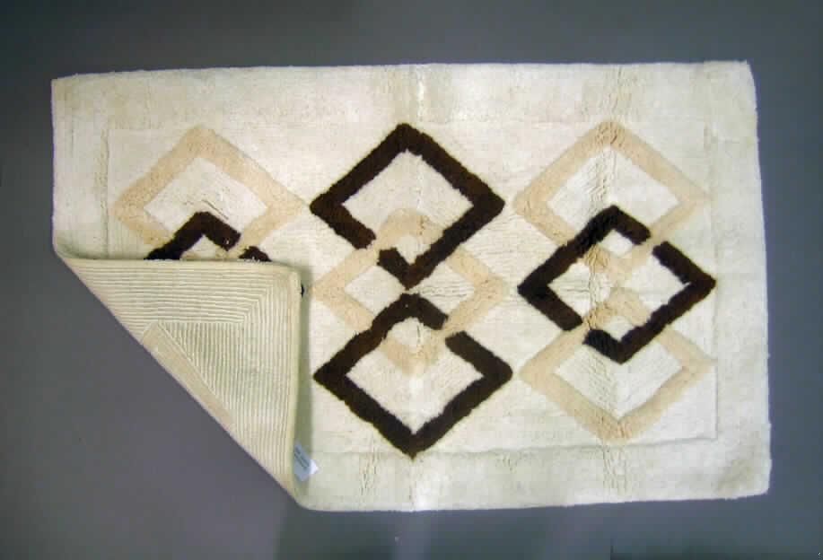 Teppich aus Spinnstoffen, sog. Badteppich (Art.-Nr. 880518), siehe Foto,
- rechteckig, mit den Abmessungen von ca. 105 cm x 62 cm,
- getuftet (Nadelflor); in einen textilen, gewebten Grund ist nachträglich ein ca. 1,5 cm hoher 
  Flor aus laut Antrag Baumwolle eingezogen worden,
- an den Rändern gesäumt (somit konfektioniert); mit einem etwa 1 cm breiten florlosen 
  Rand (deshalb keine Fliese),
- kennzeichnet sich durch seine Festigkeit, Dicke und Steifheit als Fußbodenbelag.