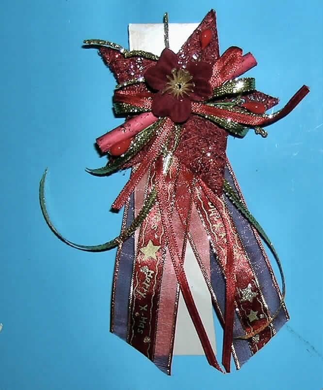 Andere konfektionierte Ware aus Spinnstoffen, sog. Weihnachtssternschleife aus Sisal zum Aufkleben, siehe Foto,
- aus verschiedenen bis zu 3 cm breiten, einfarbigen bzw. bedruckten Bändern aus Geweben sowie aus Flach-
  geflechten (Meterware der Position 5808), die teilweise zu Schleifen zusammengelegt  wurden; beide aus 
  Spinnstoffen; mit einer Gesamtlänge von ca. 11 cm,
- befestigt auf einem ca. 6 cm großen, fünfzackigen Stern aus mit  Bindemittel verfestigten Vliesstoffen aus 
  laut Antrag Sisal (pflanzlicher Spinnstoff der Position 5305 - Vliesstoff: Meterware der Position 5603),
- mit einer stilisierten Blüte aus Geweben und Kunststoff,
- mit einem eingearbeiteten, ca. 7 cm breiten Holzstäbchen und diversen Verzierungen aus Kunststoff,
- die Gewebe und Geflechte sind gegenüber dem Vliesstoff vom Umfang und Gesamteindruck vorherrschend 
  und verleihen der Ware ihren wesentlichen Charakter,
- Länge: ca. 15 cm, Breite: ca. 8 cm, Dicke ca. 2 cm,
- auf der Rückseite mit einem beidseitigen Klebeband,
- durch Zusammfügen konfektioniert; nicht handgearbeitet,
- keine Einreihung als Weihnachtsartikel in die Position 9505, da der Ware aufgrund ihres Gesamterscheinungs- 
  bildes der eindeutige Bezug zum Weihnachtsfest fehlt und sie daher traditionell nicht hauptsächlich als 
  Weihnachtsartikel verwendet wird, sondern vielmehr als Dekorationsartikel zu verschiedenen Anlässen 
  benutzt werden kann,
- keine Ware zur Innenausstattung der Position 6304, da ohne Raum bezogene Funktion.