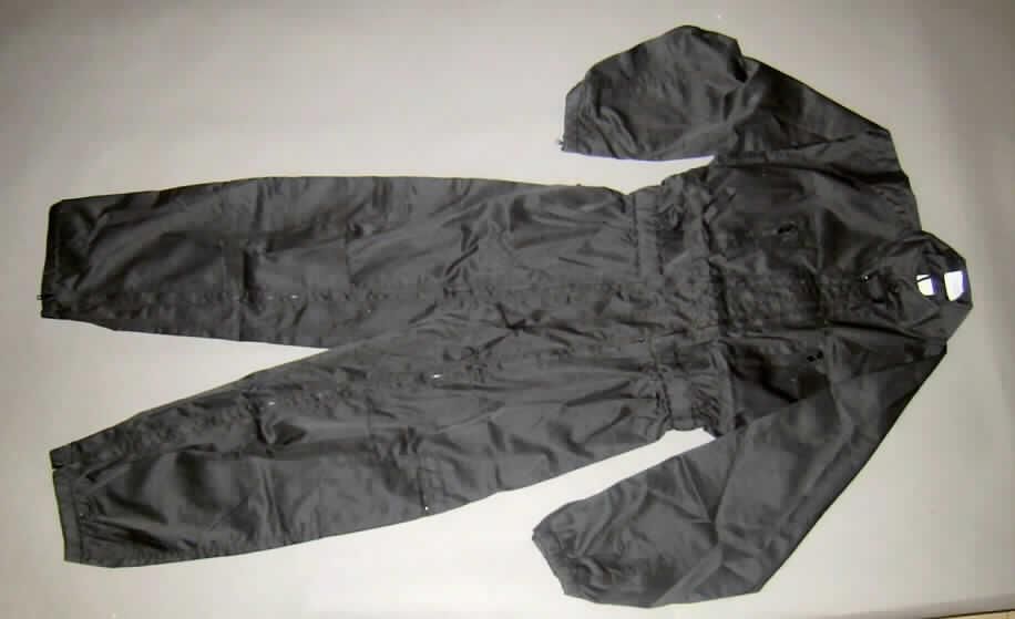 Overall für Männer (Arbeitskleidung), sog. Einsatzkombi, Größe L, siehe Foto,
- aus 0,8 mm dicken, festen, köperbindigen, einfarbigen Geweben aus laut Antrag
  65 % Polyester (synthetische Chemiefasern) und 35 % Baumwolle,
- einteilig, den ganzen Körper mit Ausnahme der Hände, der Füße und des Kopfes bedeckend,
- mit einem Stehkragen mit Knopfverschluss von links über rechts (Männerkleidung),
- vorn mit zwei vom oberen Rand bis zu den Beinabschlüssen reichenden Öffnungen mit
  durchgehenden Reißverschlüssen (laut Antrag Ein- und Ausstiegsreißverschlüsse),
- mit langen, an den Enden elastisch verengten Ärmeln, mit 15 cm hoch reichenden
  Öffnungen mit Reißverschluss,
- in Taillenhöhe elastisch verengt,
- mit zwei Brusttaschen und zwei Beintaschen, jeweils aufgesetzt und mit Reißverschluss
  sowie auf dem linken Oberarm mit einer aufgesetzten, offenen Tasche und auf beiden
  Seiten in Höhe der Hüfte mit einer ca. 16 cm langen Öffnung mit Reißverschluss, 
- ungefüttert,
- an den Beinabschlüssen elastisch verengt und gesäumt,
- lässt aufgrund des zweckbestimmten Zuschnitts, der Ausstattung (u.a. mit Doppelnähten
  gearbeitet und im Kniebereich verstärkt) und des Materials erkennen, dass er dazu bestimmt 
  ist, ausschließlich oder hauptsächlich zum Schutz der Kleidung/Person bei der Ausübung 
  einer beruflichen Tätigkeit getragen zu werden (somit Arbeits- und Berufskleidung).
