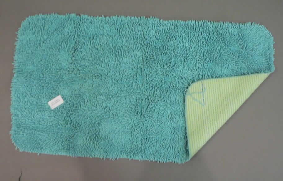 Teppich aus Spinnstoffen, sog. Badematte (Artikel-Nr. 16831), siehe Foto,
- rechteckig mit abgerundeten Ecken, laut Antrag mit den Abmessungen von ca. 50 cm x 92 cm,
- getuftet (Nadelflor); in einen textilen, gewebten Grund ist nachträglich ein ca. 2 cm hoher 
  Flor aus laut Antrag Baumwolle eingezogen worden,
- an den Rändern gesäumt, (somit konfektioniert); keine Fliese,
- auf der Unterseite laut Antrag mit Latex beschichtet,
- kennzeichnet sich durch seine Festigkeit, Dicke und Steifheit als Fußbodenbelag.