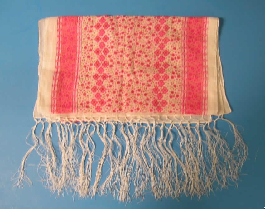 Schal, siehe Foto,
- aus 0,4 mm dicken, buntbedruckten Geweben aus laut Antrag 100% Baumwolle,
- rechteckig, in den Abmessungen: ca. 155 cm x 33 cm,
- an allen Rändern gesäumt, an den Schmalseiten mit angeknoteten Fransen (somit
  konfektioniert),
- nicht handgearbeitet.
