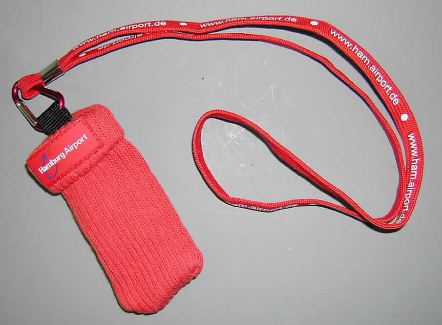 Konfektionierte Spinnstoffware, sog. "Handyhalter Socke", siehe Foto,
- wird als Band um den Hals getragen,
- Schlüsselband mit Utensilienbehälter (aus zwei Bestandteilen zusammengesetzte Ware),
  bestehend aus:
  -- einem Schlüsselband (aus verschiedenen Stoffen zusammengesetzten Ware):  
      --- aus einem 1 cm breiten, mit Schriftzügen bedruckten Band aus Geweben aus Spinn- 
          stoffen; zu einer Schlaufe von 44 cm Länge gelegt und und mit einem Clip aus 
          unedlen Metallen zusammengefügt (konfektioniert); nicht handgearbeitet, und
      --- einem Karabinerhaken aus unedlem Metall (laut Antrag: Aluminium), der in der 
          Schlaufe eingehängt ist,
      --- im Hinblick auf Umfang und Verwendungszweck bestimmen die Gewebe aus Spinn- 
          stoffen den Charakter des Schlüsselbandes,
  -- einem sog. Utensilienbehälter:
      --- rechteckig; flachliegend ca. 11 cm lang und 5 cm breit; aus einfarbigen, doppelt gear- 
          beiteten, gerippten Gewirken aus Spinnstoffen; am oberen, offenen Rand umgeschla- 
          gen; durch Zusammennähen konfektioniert; in den Karabinerhaken des Bandes einge- 
          hängt; zur Aufnahme eines Mobiltelefons o. ä. bestimmt; dient nicht zum Transport 
          oder zur Lagerung der verpackten Ware bis zum Verkauf, damit kein Sack oder Beutel
          zu Verpackungszwecken der Position 6305; wird nach Gesamtbeschaffenheit und 
          Verarbeitung nicht als Täschnerware vom Warenkreis der Position 4202 erfasst,
  -- im Hinblick auf Umfang, Wert und Verwendungszweck bestimmt das Band aus Geweben 
     gegenüber dem Utensilienbehälter aus Gewirken den Charakter der zusammengesetzten
     Ware.
