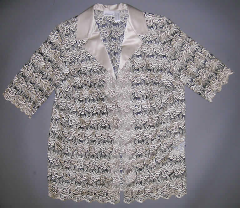 Zweiteilige Zusammenstellung bestehend aus einer Bluse und einer Jacke für Frauen, sog. Blusenset, Art. 72017, Größe 46, siehe Foto
- in gemeinsamer Aufmachung für den Einzelverkauf,
- Jacke:
-- aus bis zu 1,7 mm dicken Stickereien der Position 5810 aus lt. Antrag 
   85 % Polyester und 15 % Polyamid (beides synthetische Chemiefasern), 
-- über den Schritt reichend (Rückenlänge: 76 cm), mit etwa 10 cm hoch reichenden
   Seitenschlitzen,
-- mit einem halsfernen, V-förmigen Ausschnitt mit Reverskragen; mit einem Besatz aus 
   glänzenden Geweben aus lt. Antrag 100 % Polyester,
-- vorn mit einer durchgehenden Öffnung, im Brustbereich mit einem einzigen Knopf von 
   rechts über links zu schließen (Frauenkleidung),
-- aufgrund der lediglich im Brustbereich befindlichen Verschlussvorrichtung keine 
   Hemdbluse der Position 6206,
-- mit kurzen Ärmeln, 
-- ungefüttert; weit geschnitten,
-- an den Ärmelenden und am unteren Rand abgepasst gearbeitet.