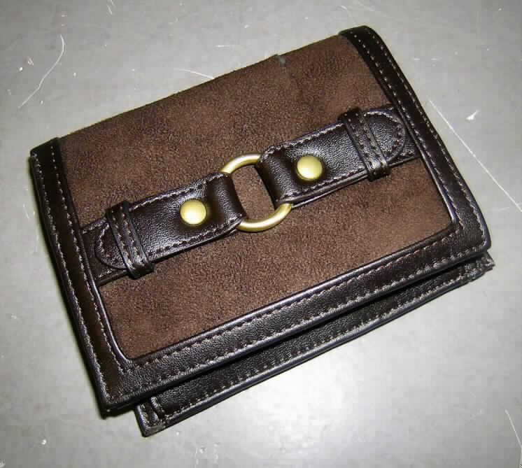 Geldbörse, Taschenartikel, siehe Foto, 
- mit einer Außenseite aus Spinnstoffen (charakterbestimmend aufgrund des Umfangs 
  (die Außenseite des Börsenkorpus ist mit einem ca. 1 cm breiten aufgenähten Streifen 
  aus Kunststofffolien eingefasst und auf der Vorderseite mit einem 2 cm breiten Zierriegel 
  aus Kunststofffolien versehen)),
- mit Abmessungen von ca. 13 x 10 x 3 cm (zusammengeklappt), 
- dreifach aufklappbar, ohne Verschluss,
- mit zwei Scheinfächern, einem Münzfach mit Druckknopfverschluss und diversen 
  Einsteckmöglichkeiten für Scheckkarten, Fahrkarten und Visitenkarten,
- augenscheinlich nicht handgearbeitet.