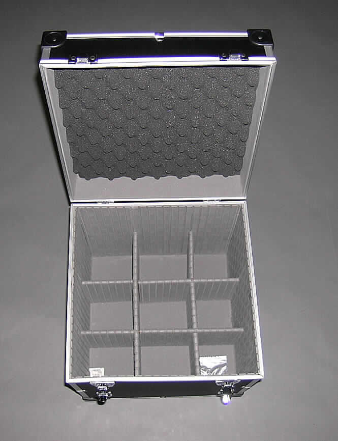 Handkofferähnliches Behältnis, sog. Universal-Gerätekiste, siehe Fotos, 
- mit einer Außenseite aus schwarz gefärbtem, strukturiertem Aluminium (Ergebnis der 
  augenscheinlichen Untersuchung), welches auf einer Unterkonstruktion aus entsprechend 
  zugeschnittenen Holzfaserplatten aufgeklebt ist, 
- mit einem Rahmen aus Aluminium und Eckverstärkungen aus Kunststoff, 
- mit den Abmessungen von ca. 36,7 x 38,0 x 39,4 cm, 
- mit einem Handtragegriff am Deckel, 
- mit zwei abschließbaren Bügelschlössern, 
- innen mit Schaumkunststoff ausgekleidet, sowie mit verstellbaren Stegen aus mit Schaum- 
  kunststoff verkleideten Holzfaserplatten zur beliebigen Fächereinteilung ausgestattet.