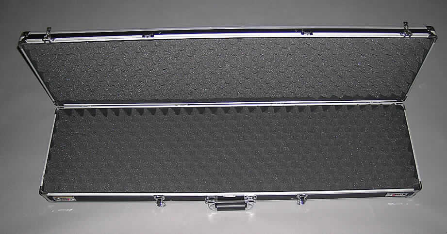 Handkoffer, sog. Instrumenten- oder Waffenkoffer, siehe Fotos, 
- mit einer Außenseite aus schwarz gefärbtem, strukturiertem Aluminium (Ergebnis der 
  augenscheinlichen Untersuchung), welches auf einer Unterkonstruktion aus entsprechend 
  zugeschnittenen Holzfaserplatten aufgeklebt ist, 
- mit einem Rahmen aus Aluminium und Eckverstärkungen aus Stahlblech, 
- mit den Abmessungen von ca. 126 x 36 x 14 cm, 
- mit einem Handtragegriff,
- mit zwei Zahlenschlössern und zwei Bügelschlössern, 
- innen mit Schaumkunststoff ohne spezielle Aussparungen ausgekleidet, 
- zum Transport von Waffen oder Musikinstrumenten vorgesehen.
