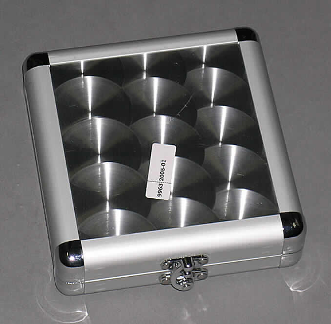 Handkoffer, sog. CD-Koffer, siehe Fotos, 
- mit einer Außenseite aus mattem, strukturiertem Aluminium (Ergebnis der augenscheinli- 
  chen Untersuchung), welches auf einer Unterkonstruktion aus entsprechend zuge- 
  schnittenen Holzfaserplatten aufgeklebt ist, 
- mit einem Rahmen aus Aluminium und Eckverstärkungen aus Kunststoff, 
- mit den Abmessungen ca. 17 x 14,8 x 4,4 cm, 
- mit einem Bügelschloss, 
- innen mit Scherstaub beflockt und mit zehn klarsichtigen Doppelhüllen aus Kunststofffolie 
  mit Vliesstoffmittellagen zur Aufnahme von 20 CD's oder CD-ROM's.