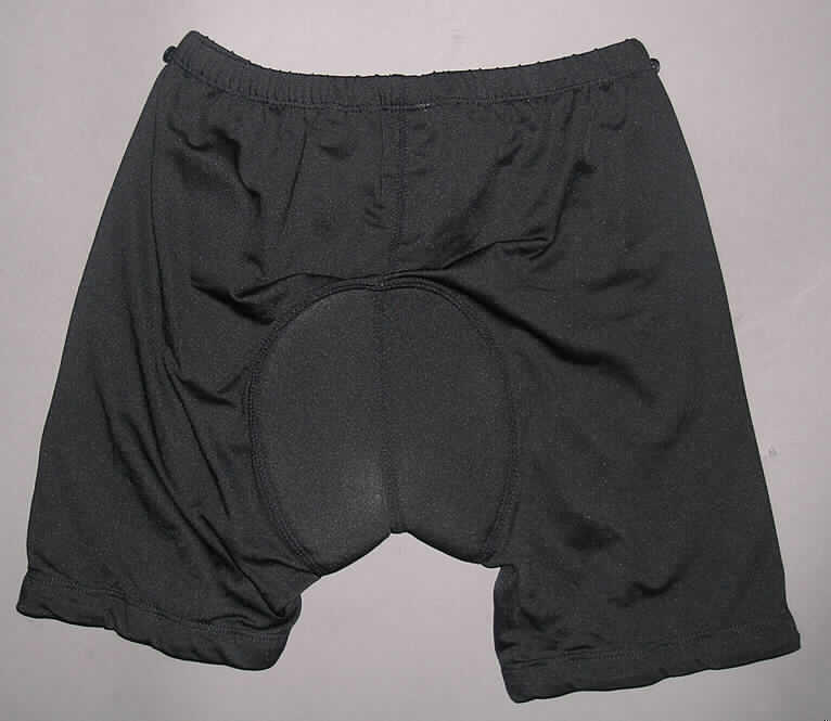 Zwei miteinander verbundene Kleidungsstücke, bestehend aus einer kurzen Hose aus Geweben für Knaben (außen) und einer kurzen Hose aus Gewirken (innen), sog. Kinder - Fahrradhose kurz, Größe 146/152, 
siehe Fotos,
- beide Kleidungsstücke sind durch Knöpfe und Schlaufen am Taillenbund miteinander 
  verbunden, können aber auch separat getragen werden,
- kurze Hose aus Gewirken:
-- aus 0,5 mm dicken, einfarbigen Gewirken aus laut Antrag 94% Polyester und 6% Elastan
   (beides synthetische Chemiefasern),
-- in der Taille abschließend, mit einem elastischen Taillenbund mit angenähten Knöpfen
   zur Befestigung an der kurzen Hose aus Geweben,
-- ohne Öffnung und ohne Verschluss; ohne Merkmale, die auf einen bestimmten Trägerkreis 
   (Knaben oder Mädchen) hinweisen (unisex),
-- mit eingenähtem Polster im Schritt- und Gesäßbereich,
-- mit kurzen Hosenbeinen, die nicht die Knie bedecken (Seitenlänge: 34 cm),
-- an den Beinabschlüssen durch Umschlagen und Festnähen gesäumt und mit einem 
   elastischen, rutschhemmenden Band ausgestattet.
