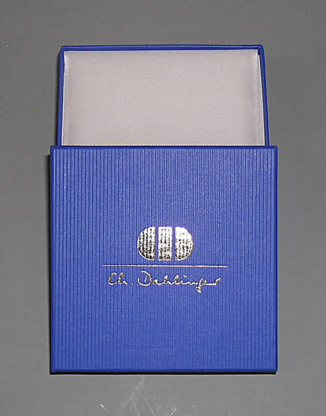 Schachtel für Schmuckwaren, sog. Kartonschachtel mit Papierüberzug, Serie 140, siehe 
Foto, 
- zweiteilig, bestehend aus Bodenteil und Deckel, 
- mit einer Außenseite aus Papier (streifenartig geprägt), 
- - auf einer Unterlage aus Pappe aufgebracht, 
- ohne Verschluss, 
- mit einem für eine Schmuckware besonders hergerichteten Inneneinsatz aus mit Scher- 
  staub beflocktem Schaumkunststoff,
- mit einem um den Inneneinsatz gefalteten Zuschnitt aus Schaumkunststoff mit einem Über- 
  zug aus Gewebe als Polsterung der Schmuckware, 
- mit den Abmessungen von ca. 8,5 x 8,5 x 2,5 cm.