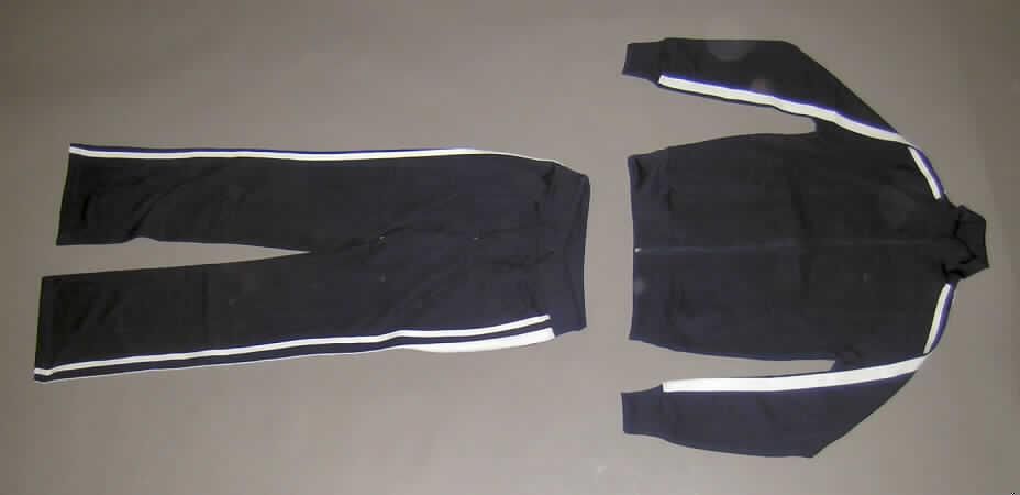 Trainingsanzug, sog. Men´s Tracksuit (Artikel 7102), Größe M, siehe Fotos,
- bestehend aus einem Oberteil und einer langen Hose,
- gemeinsam im Polybeutel aufgemacht,
- aus 1,1 mm dicken, einfarbigen Gewirken aus laut Antrag 80 % Polyester (synthetische
  Chemiefasern) und 20 % Baumwolle; mit aufgenähten, kontrastfarbenen Streifen aus
  Gewirken,
- erkennbar dazu bestimmt, ausschließlich oder im Wesentlichen bei der Ausübung eines
  Sports getragen zu werden,
- ungefüttert,
- Oberteil: 
-- über die Taille reichend (Rückenlänge: 64 cm),
-- mit einem Stehkragen,
-- vorn mit einer durchgehenden Öffnung mit Reißverschluss,
-- mit langen Ärmeln mit verengenden, gerippten Bündchen, 
-- mit zwei eingesetzten, offenen Taschen unterhalb der Taille, 
-- am unteren Rand mit einem verengenden, gerippten Bund,
- lange Hose: 
-- in der Taille abschließend, mit einem gerippten Taillenbund mit Kordelzug,
-- ohne Öffnung und ohne Verschluss,  
-- mit einer aufgesetzten, offenen Gesäßtasche,
-- mit knöchellangen Hosenbeinen,
-- an den Beinabschlüssen gesäumt.