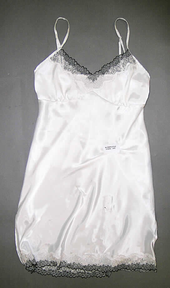 Unterkleid für Frauen, Größe S, siehe Foto,
- aus 0,2 mm dicken, einfarbigen (weiß), glänzenden Geweben (Satin) aus lt. Antrag 100%
  Polyester (synthetische Chemiefasern), 
- über den Schritt hinausreichend (Rückenlänge: 82 cm),
- mit verstellbaren Trägern,
- mit leicht konvex ausgearbeiteten Büstenteilen, die jedoch keine Stützfunktion der Brust 
  bewirken, somit keine Miederware der Position 6212,
- aufgrund des Schnitts eindeutig als Frauenkleidung erkennbar,
- im Brustbereich und am unteren Rand aus Stickerei gefertigt,
- mit 20 cm hoch reichenden Seitenschlitzen am unteren Rand.